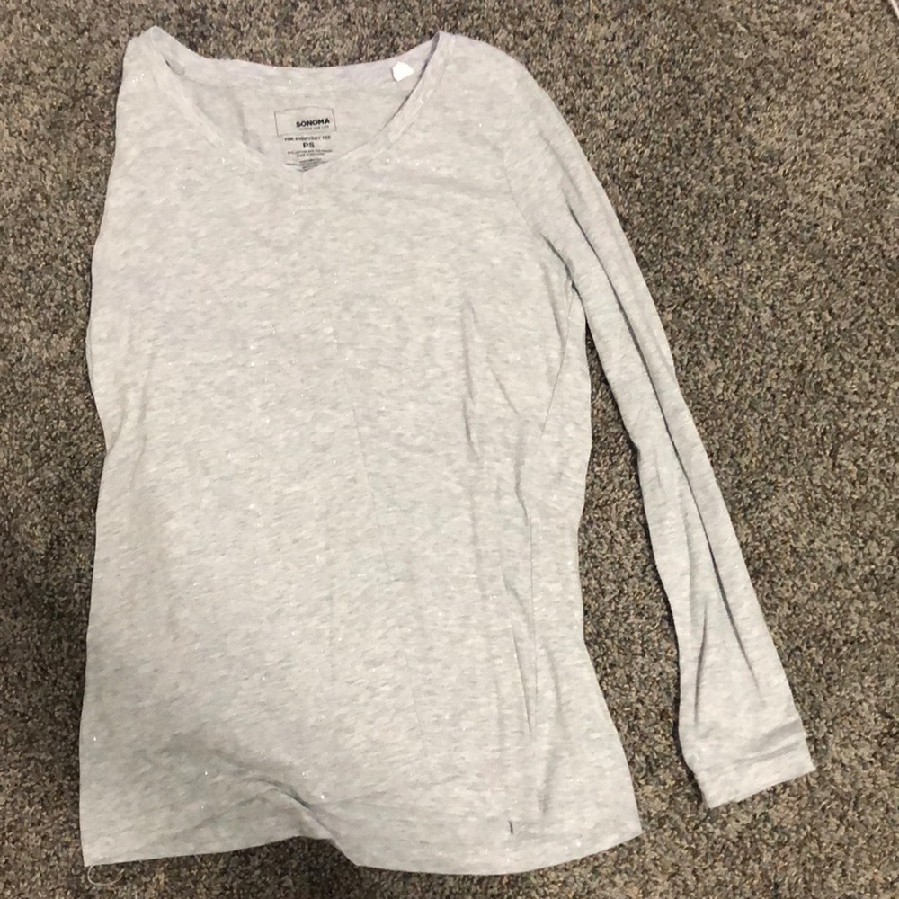 A gray, sparkly, long sleeves shirt.